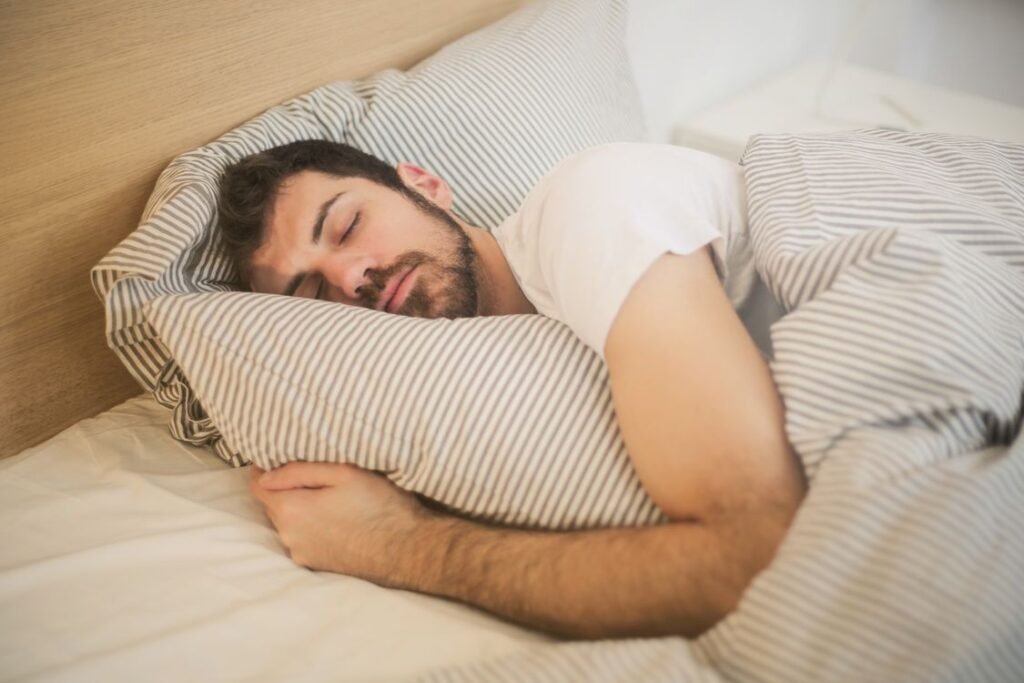 Man sleeping, showing sleep apnea symptoms in men like snoring and fatigue