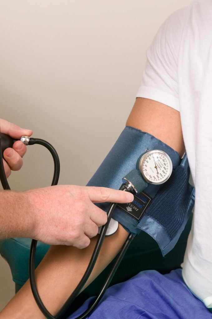 Doctor checking a man's blood pressure by age during a checkup