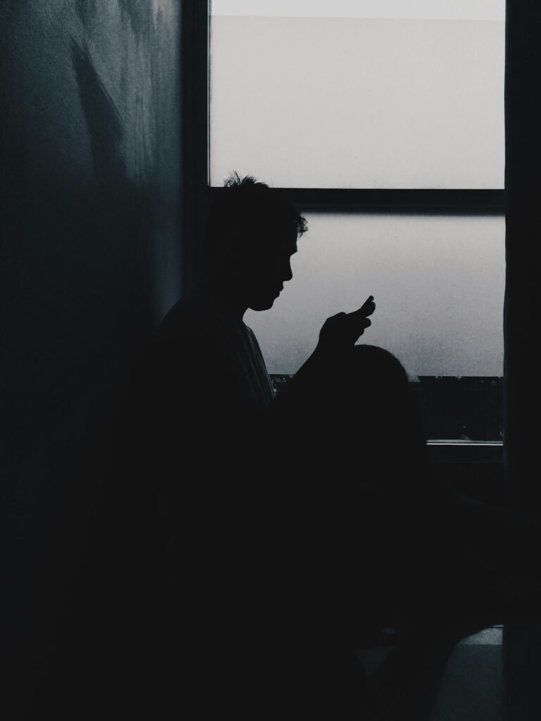 Man using phone in bed showing the effects of blue light and sleep