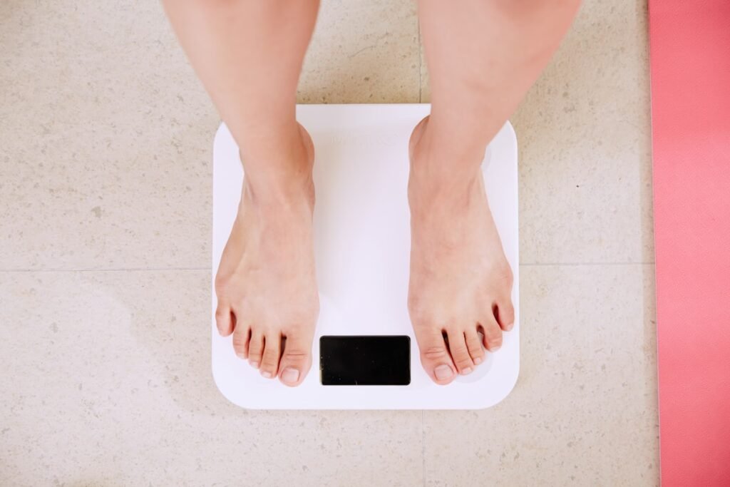 Person standing on a digital scale checking healthy body fat percentage for men