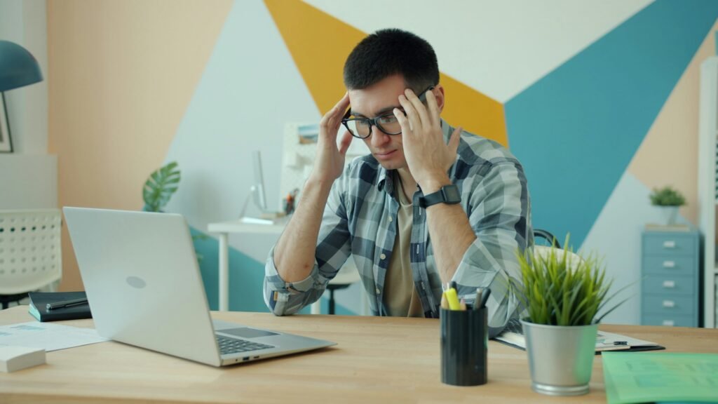 Distracted man at laptop showing brain fog causes