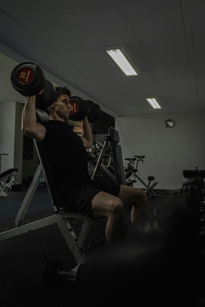 fit man in his 40s lifting dumbbells while building muscle after 40