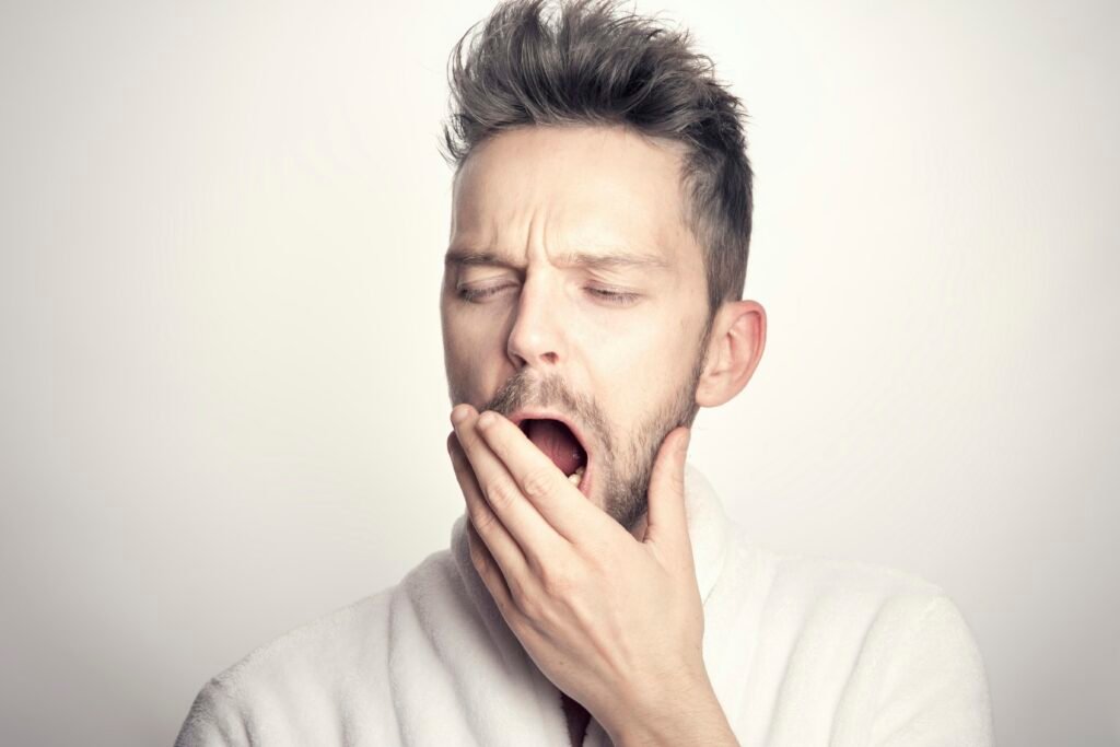 well-rested man waking up, illustrating how much sleep do men need