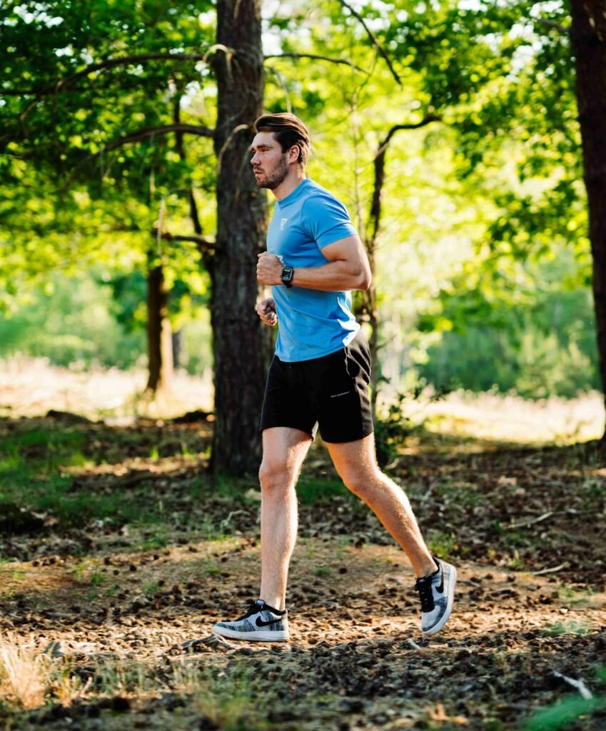 Man running outdoors through the woods doing zone 2 cardio