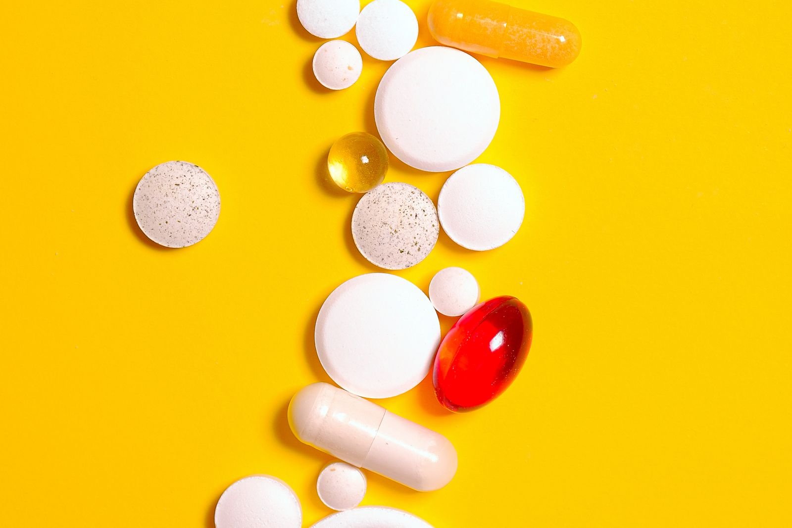 Assorted tablets and capsules on a bright background