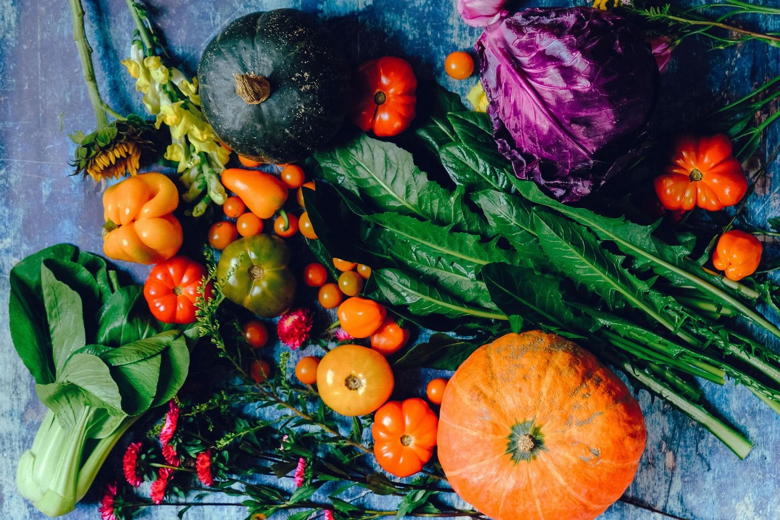 Assortment of fresh vegetables including pumpkin and greens