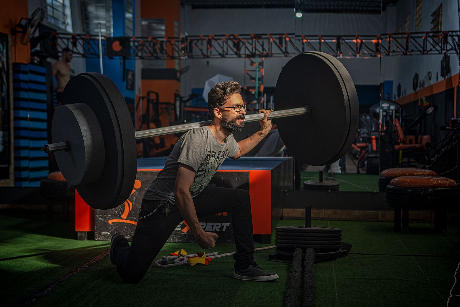 Bearded man squatting with a barbell in a gym