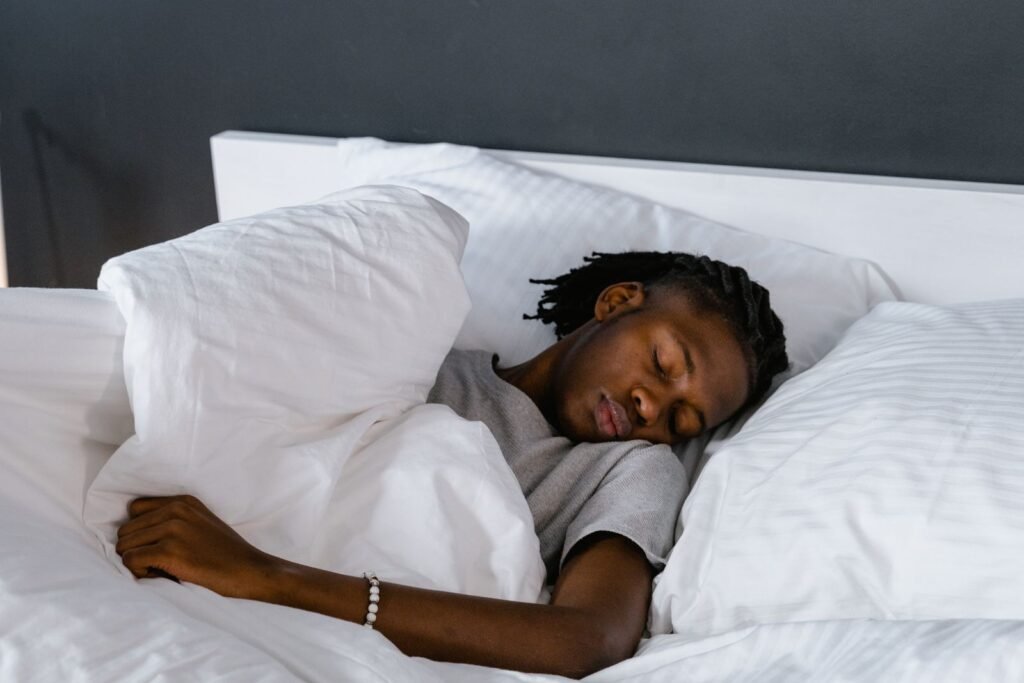 Man sleeping on his side with white pillows