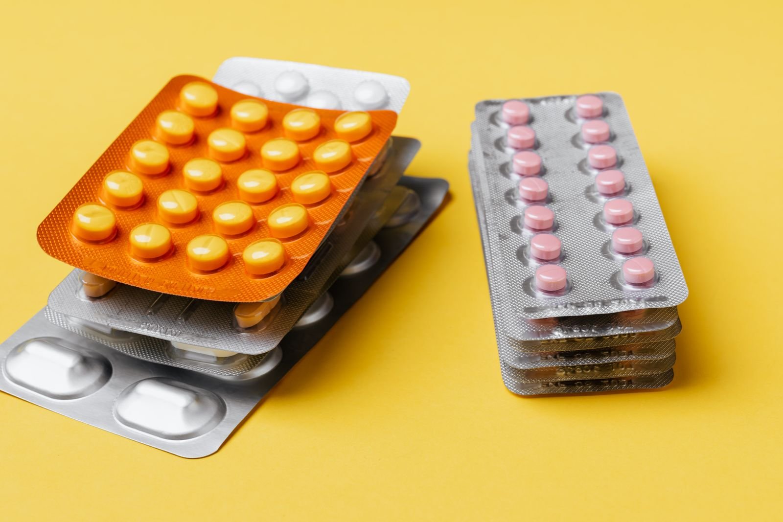 Blister packs of tablets on a yellow background