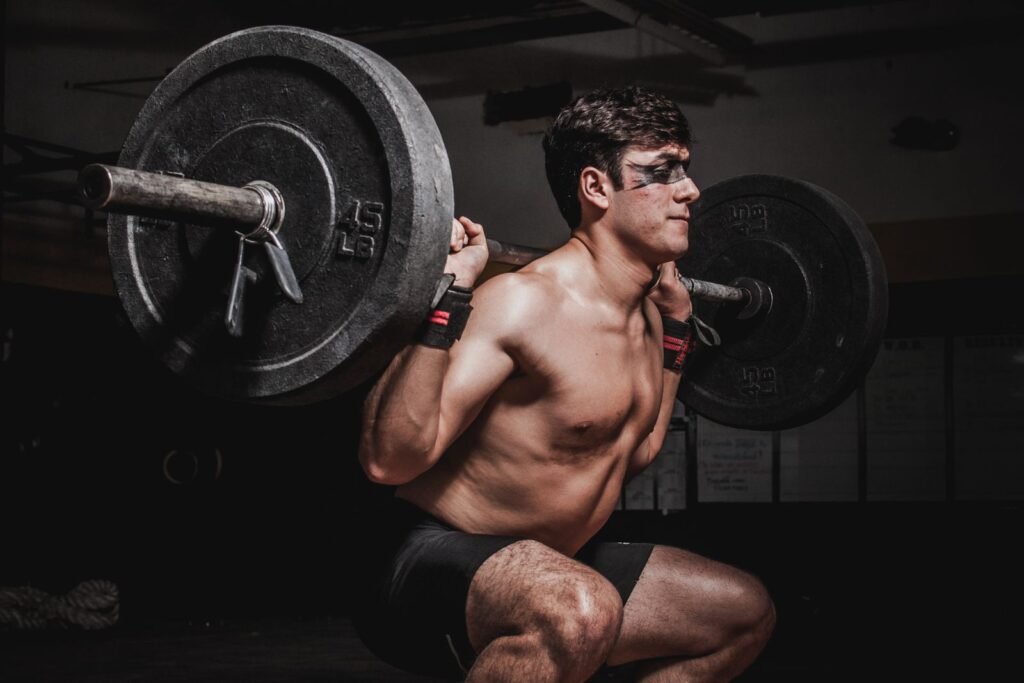 Lean muscular man performing a barbell squat