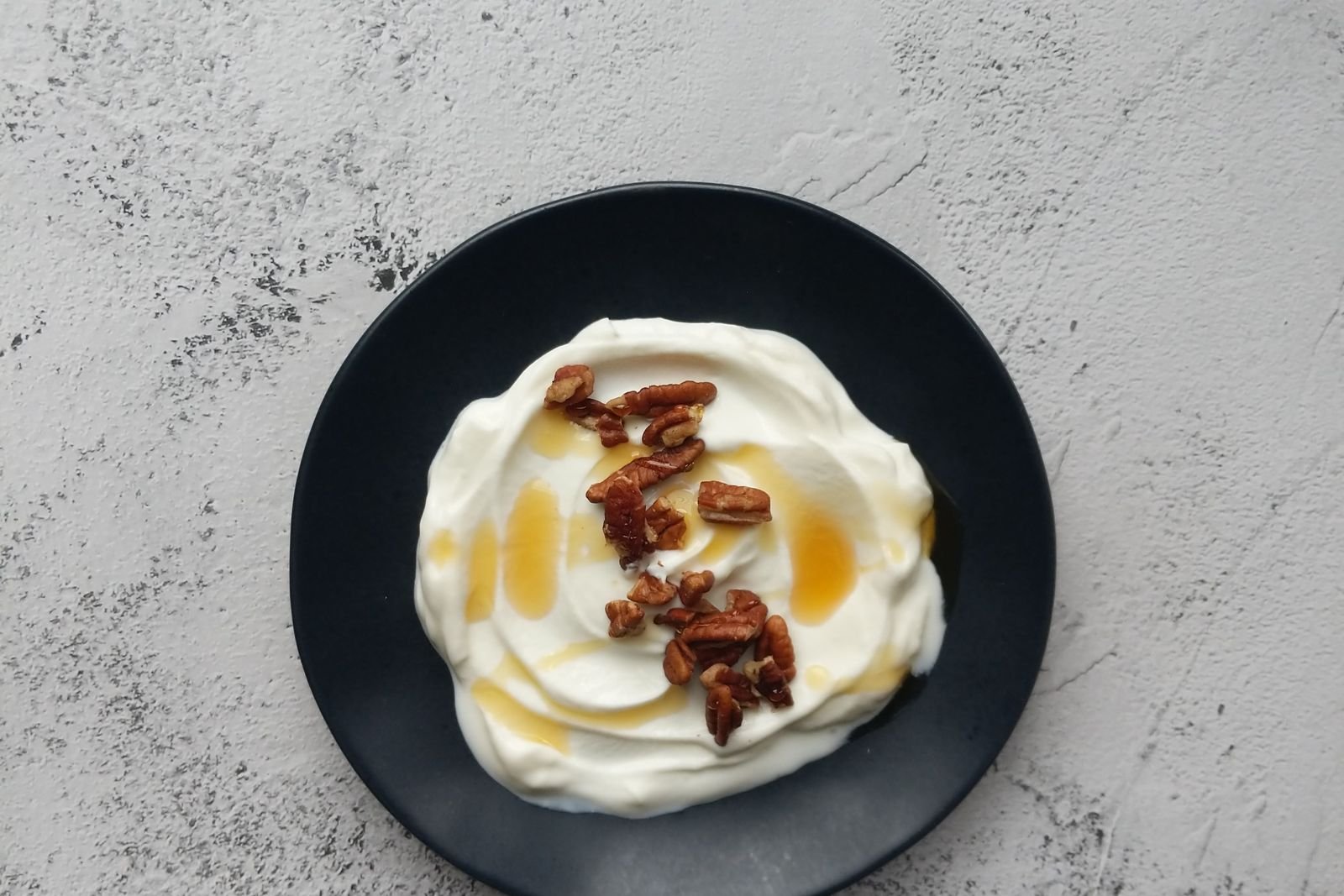 Bowl of yogurt served on a dark plate