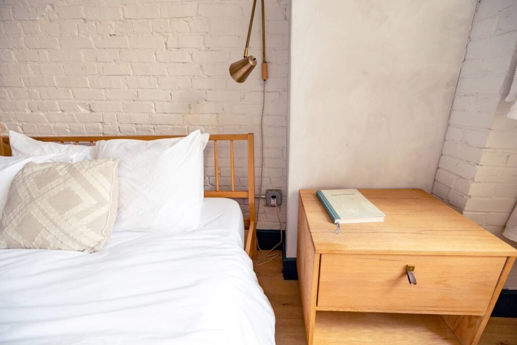 Bright bedroom with a made bed and a wooden nightstand