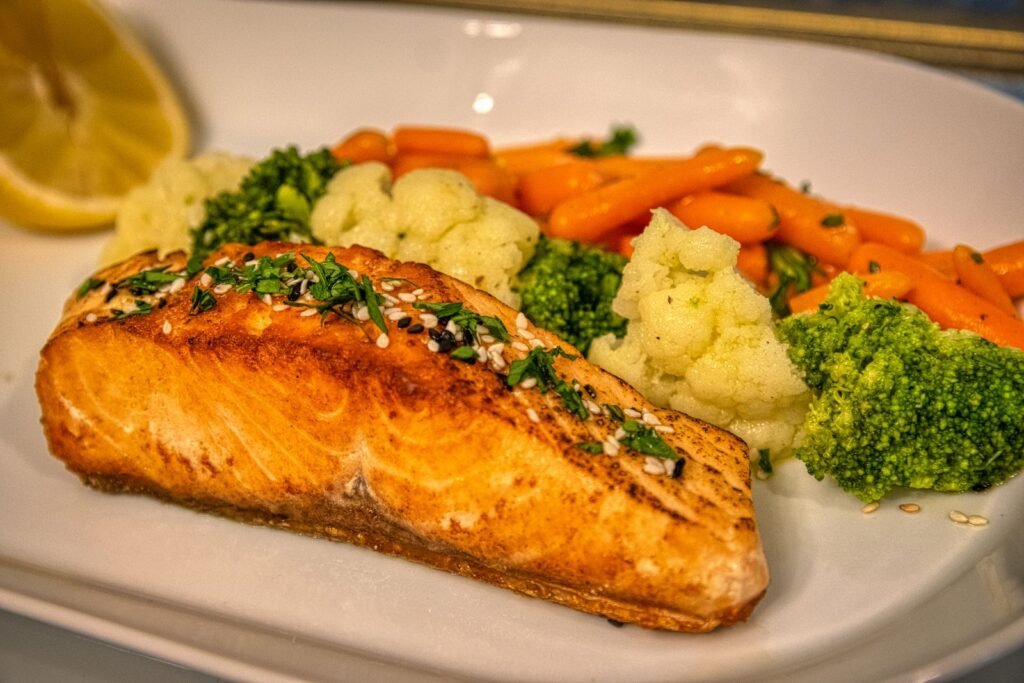 Grilled salmon fillet with broccoli, carrots and cauliflower, an anti-inflammatory meal for healthy aging