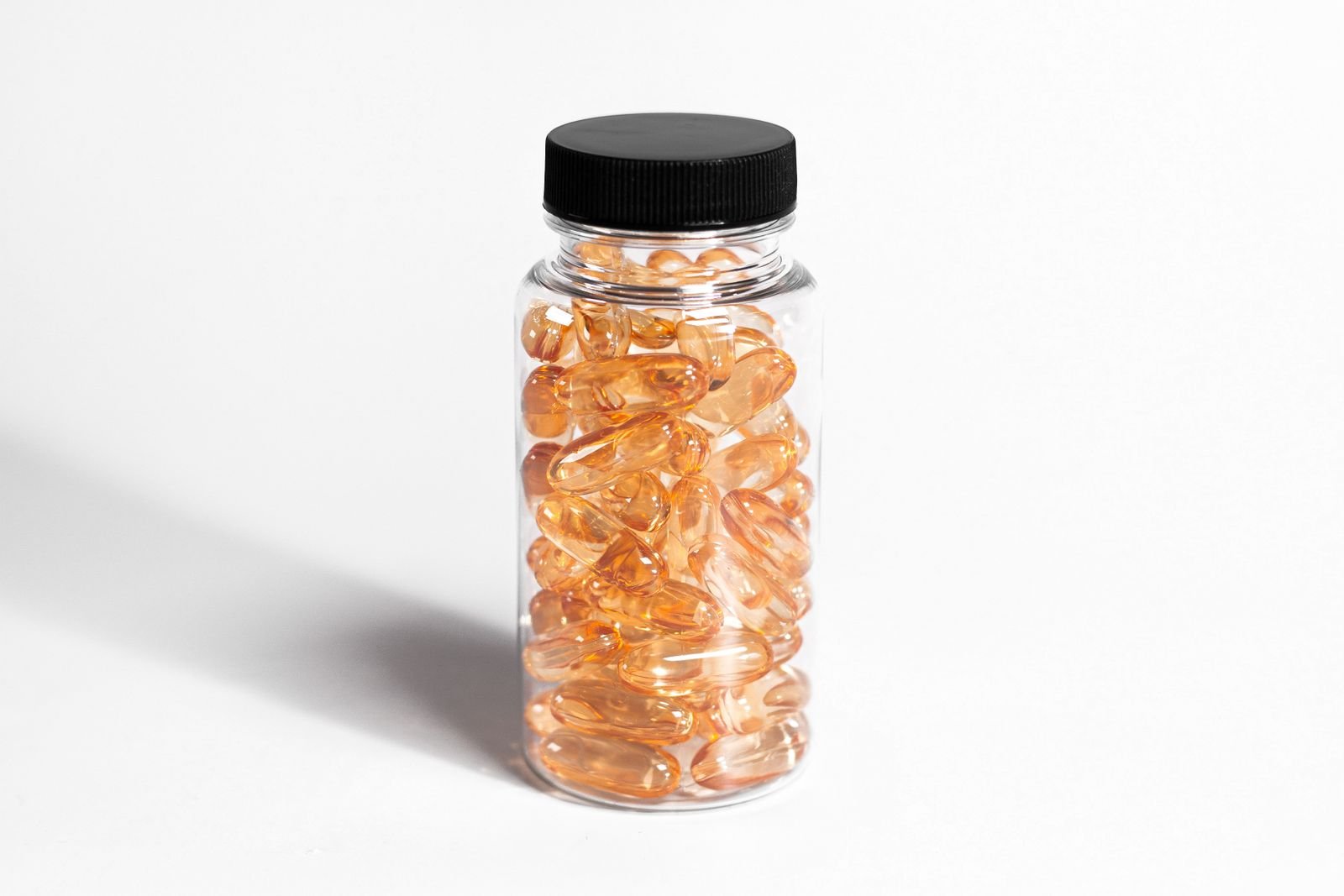 Clear bottle of amber softgel capsules