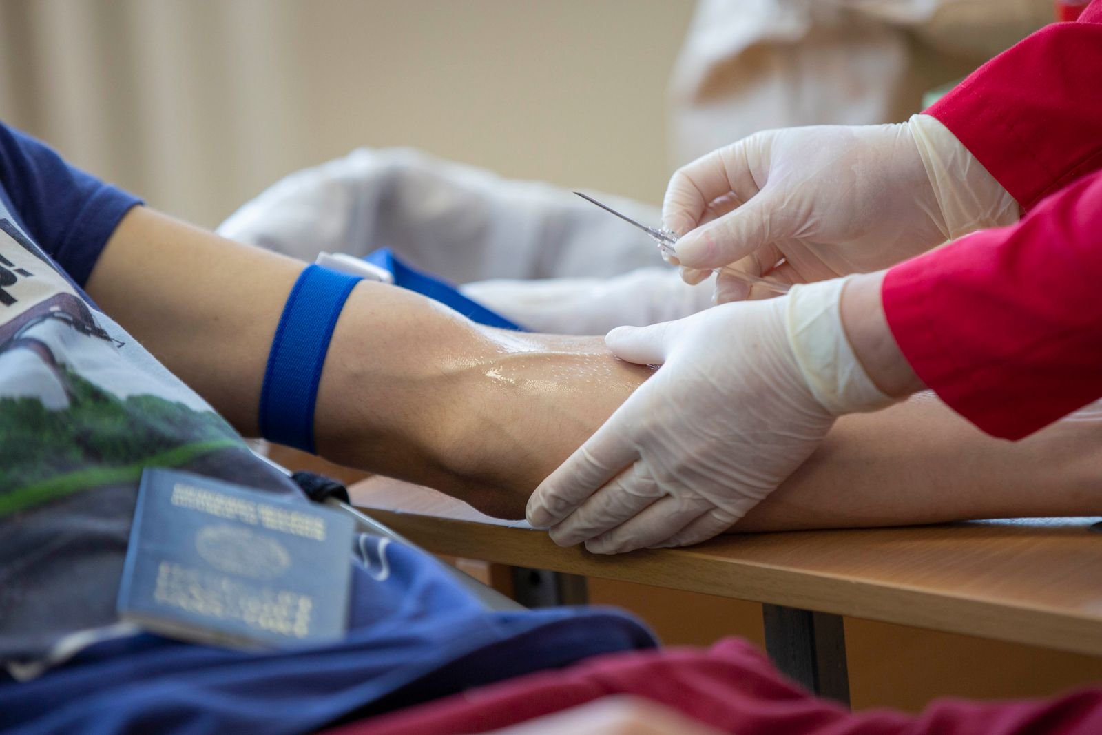 Clinician drawing a blood sample from a patient's arm