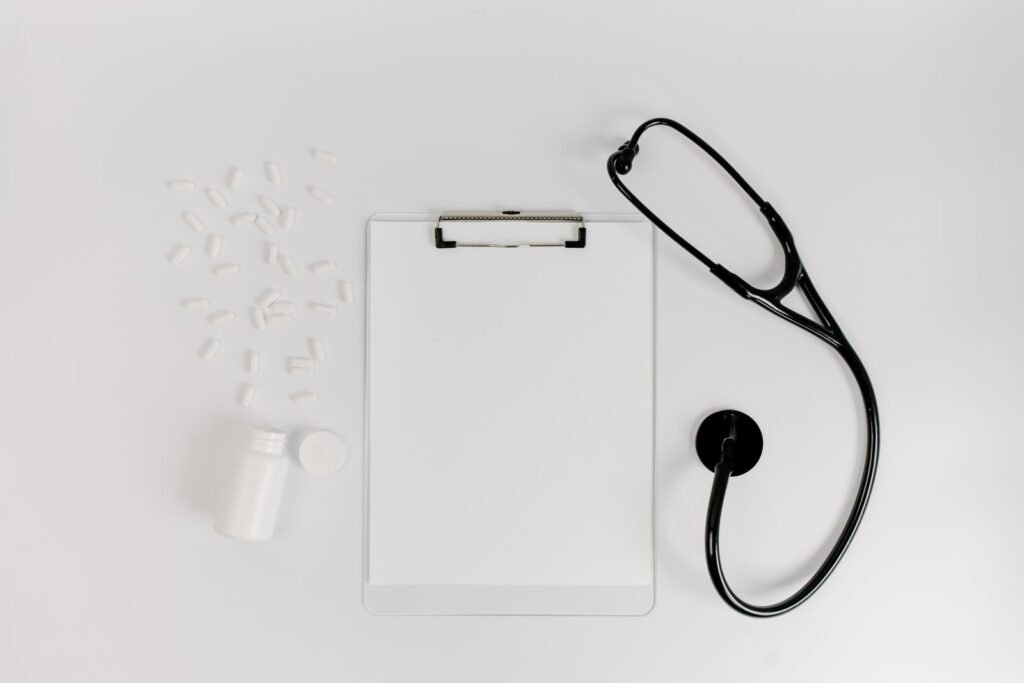 Clipboard and stethoscope on a white table