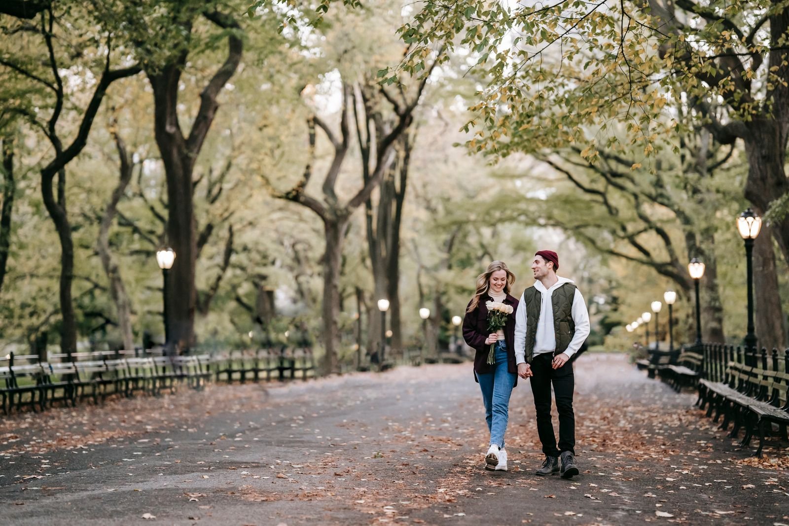 Couple walking hand in hand through an autumn park