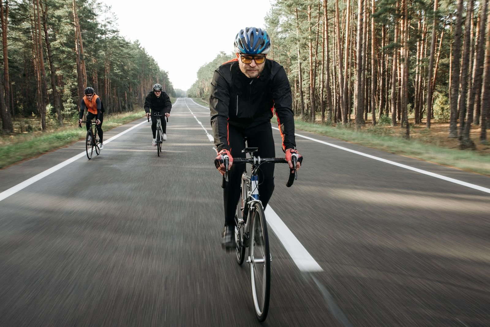 Cyclists riding a quiet forest road