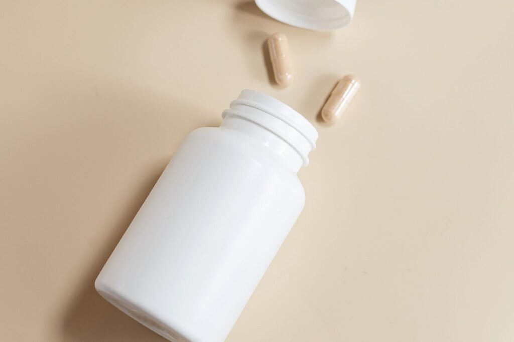 White supplement bottle with capsules on a plain background
