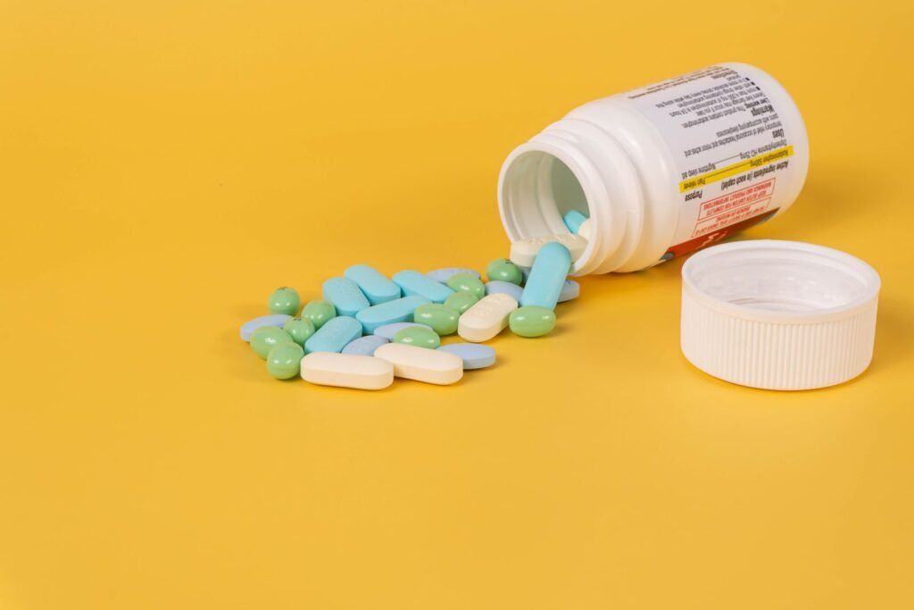 Pills spilling from a bottle onto a bright surface