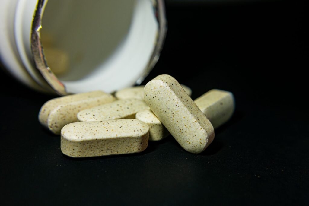 White capsules spilled from a supplement bottle