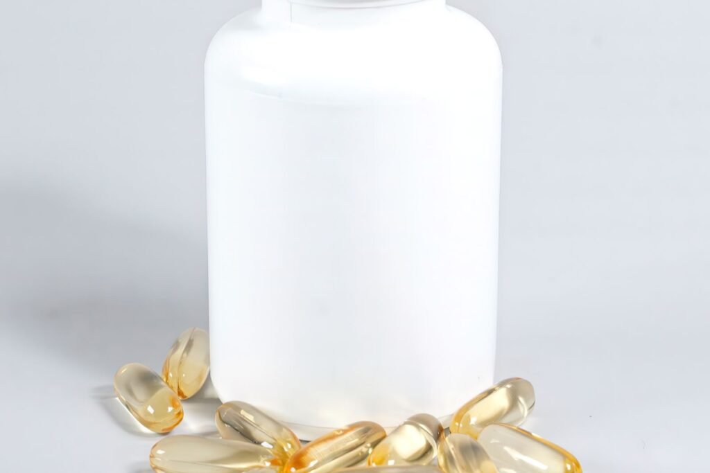 White supplement bottle with capsules scattered beside it