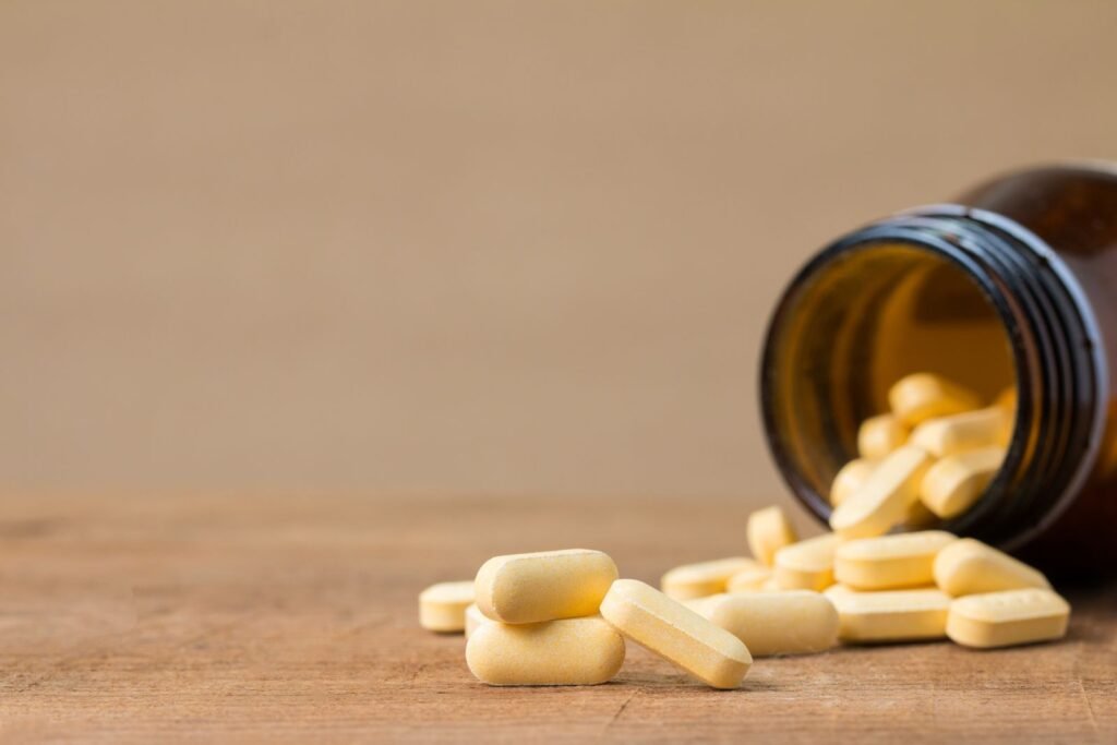 Yellow tablets spilling from a brown glass bottle