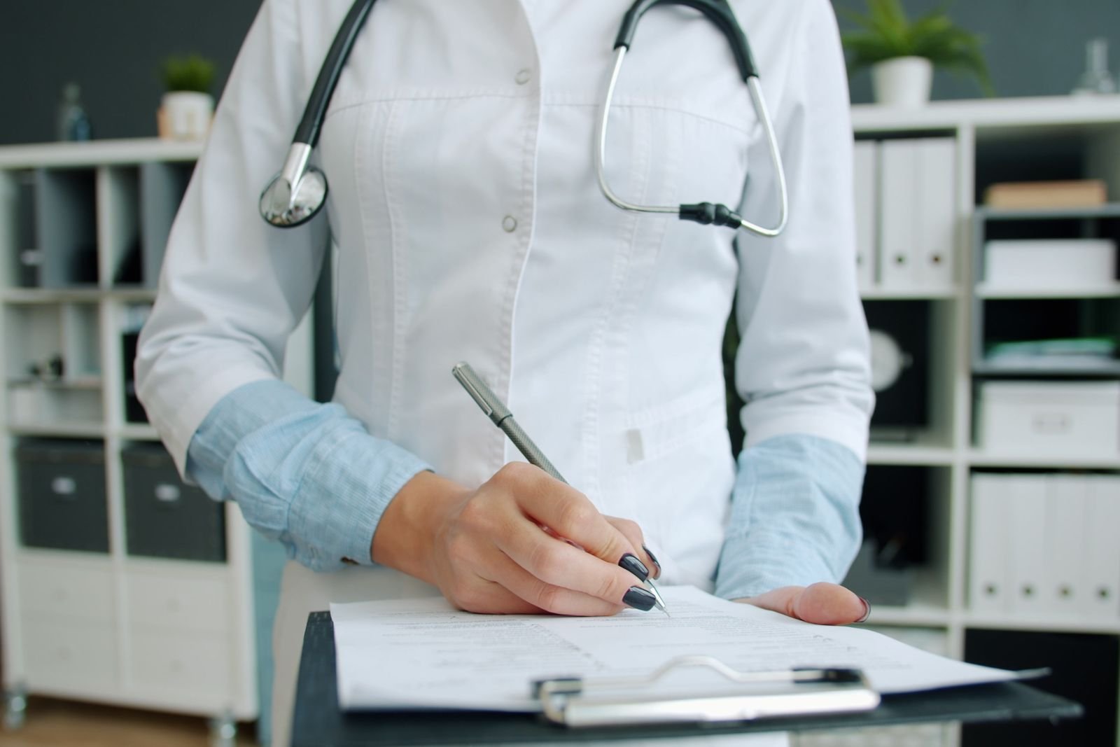 Doctor writing notes on a clipboard