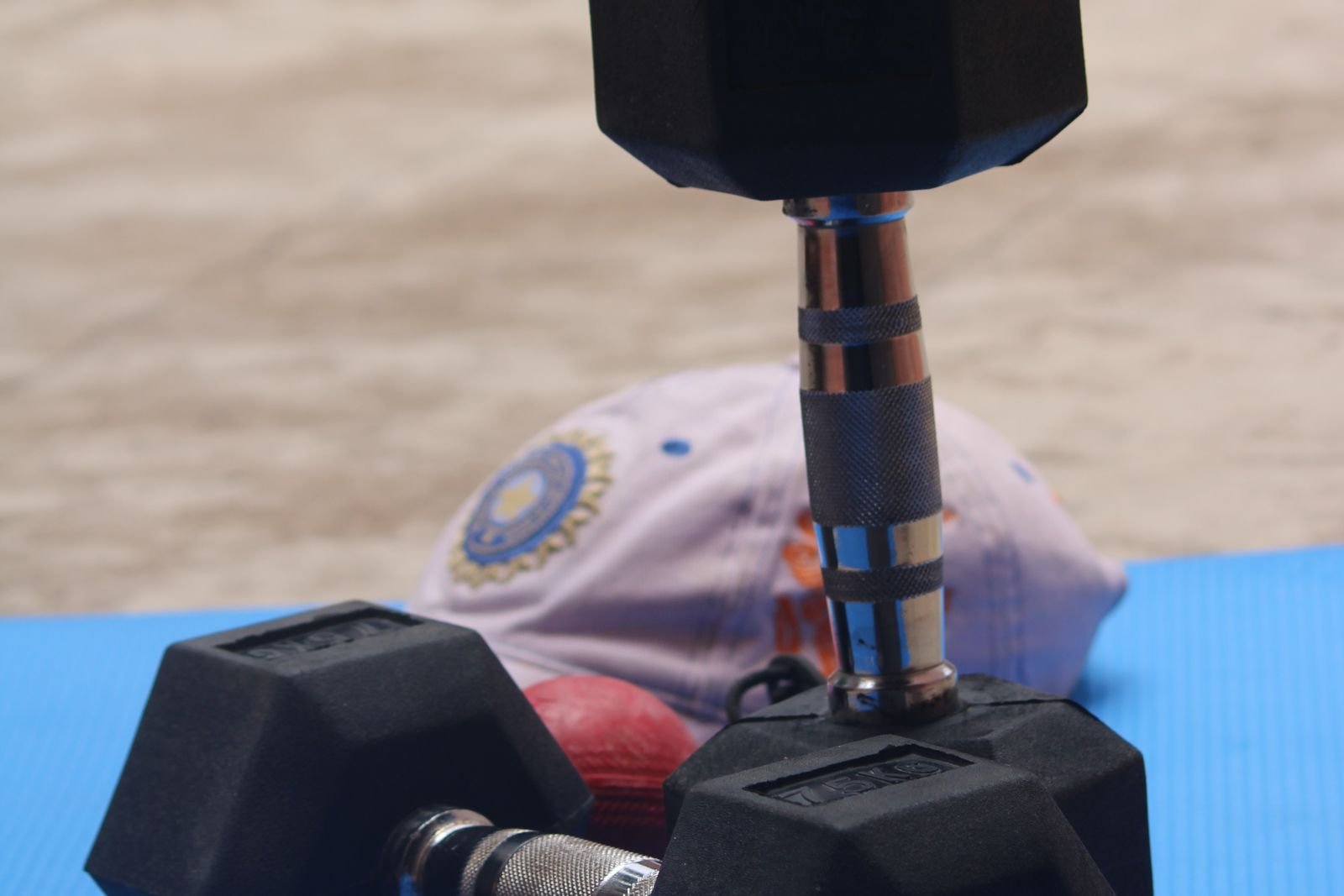 Dumbbell resting on a gym mat between sets