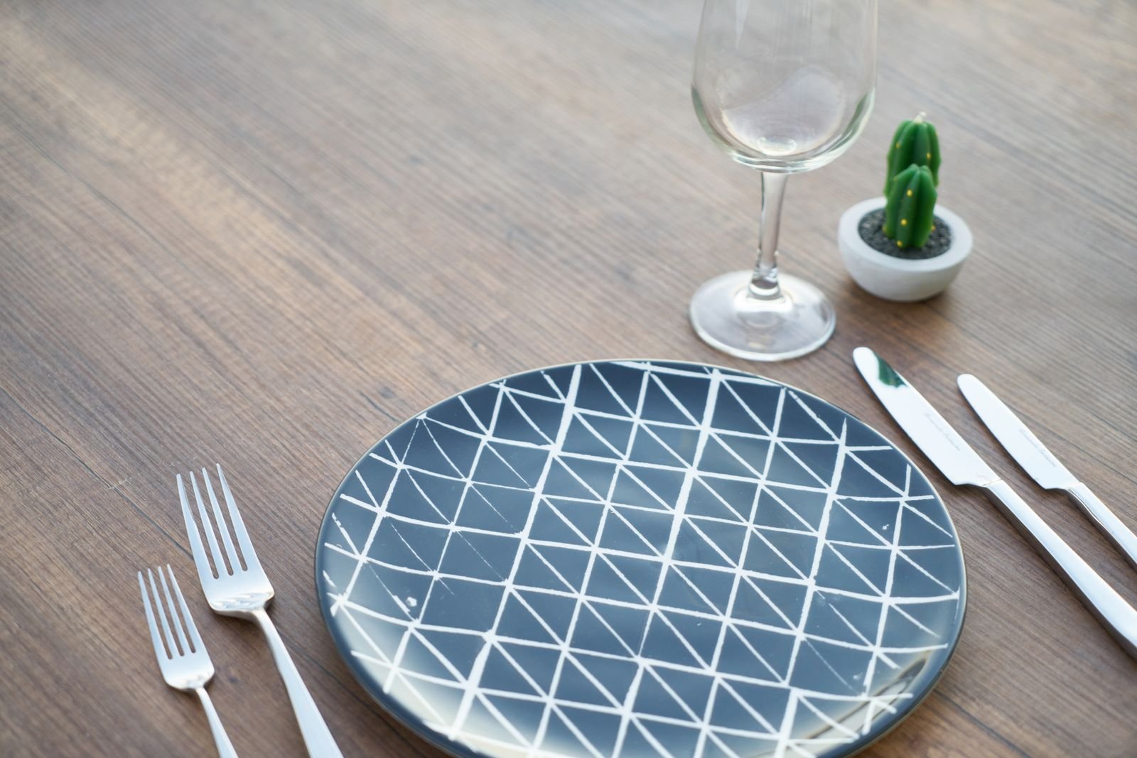 Empty patterned plate with cutlery and a glass