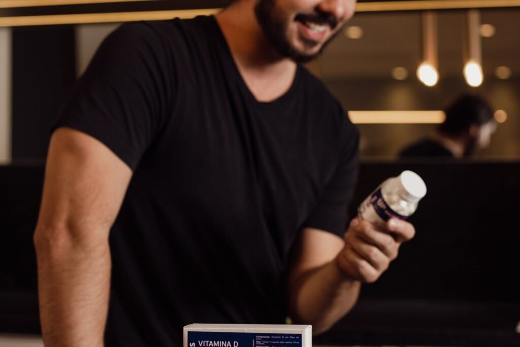 Man standing in a kitchen examining a supplement bottle