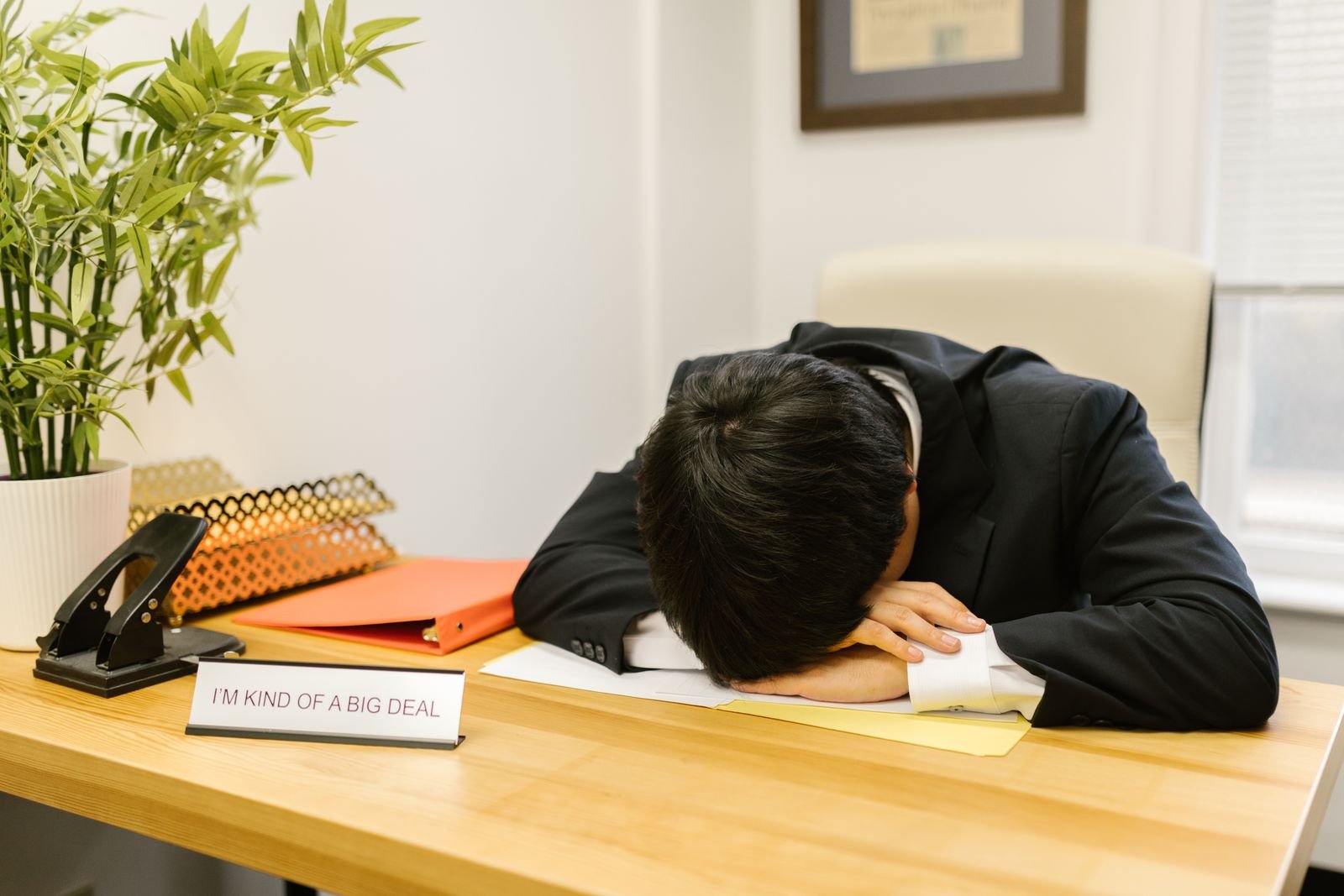 Exhausted man resting his head on his desk at work