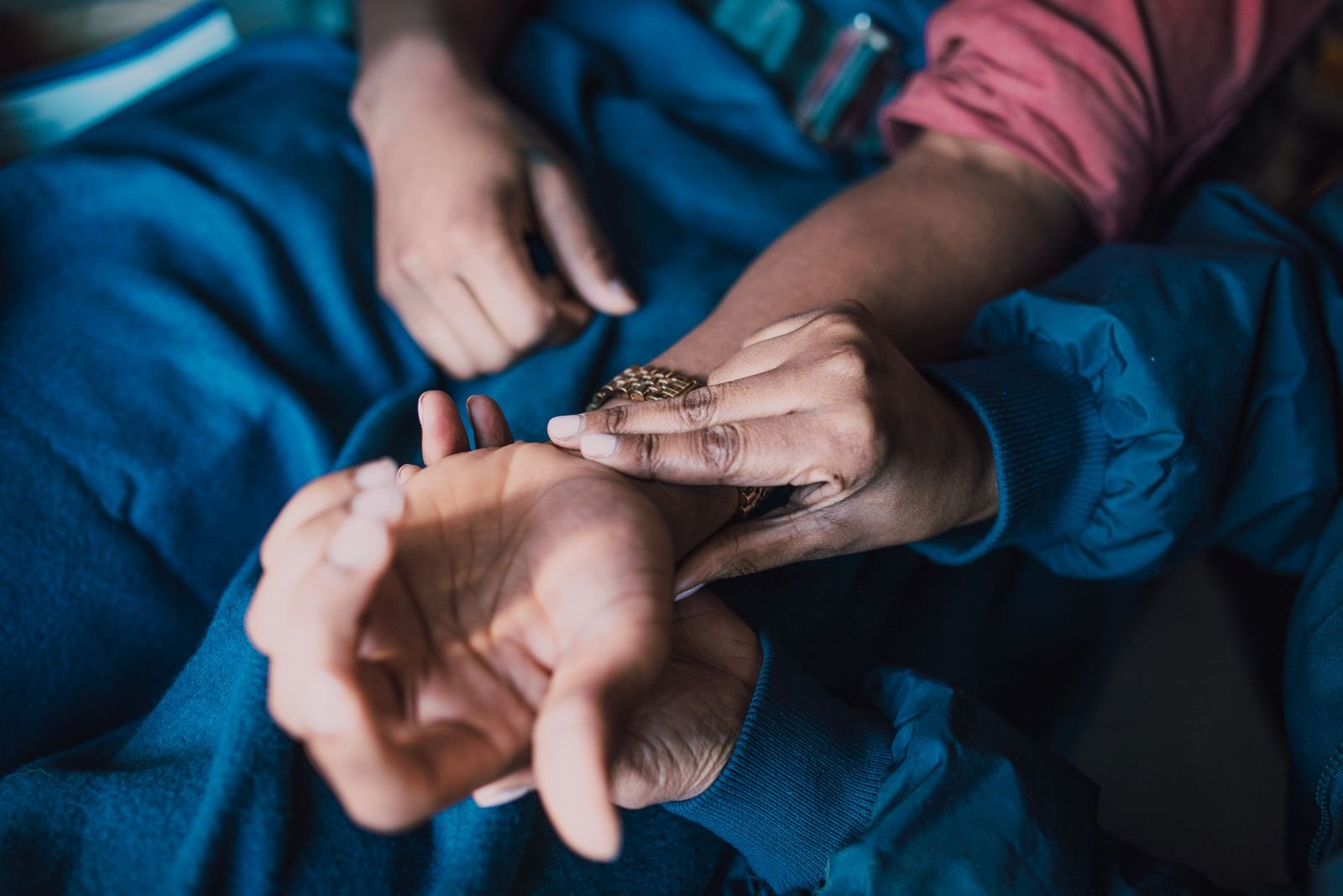 Fingers checking the pulse at the wrist