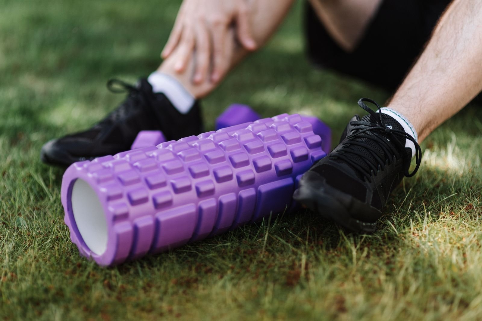 Foam roller and trainers on the grass