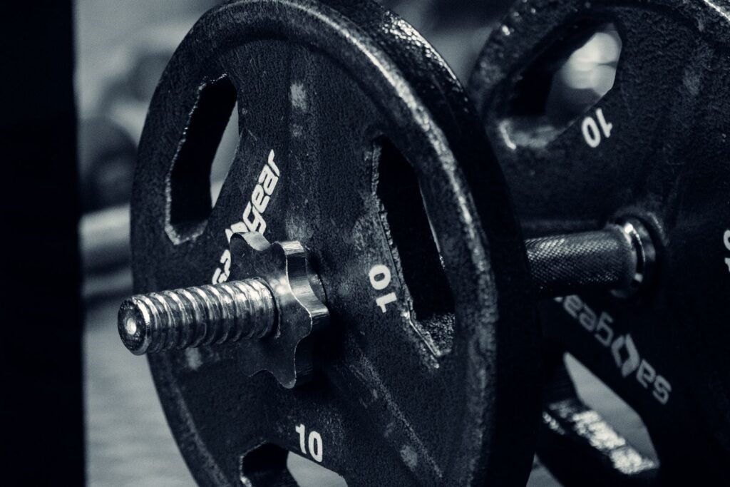 Hand gripping an iron adjustable dumbbell loaded with plates