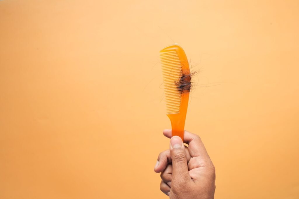 Hand holding a comb with loose hair