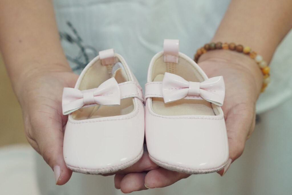 Hands holding a pair of baby shoes