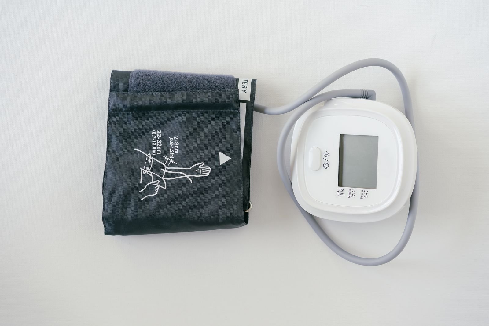 Home blood pressure monitor with the cuff beside it