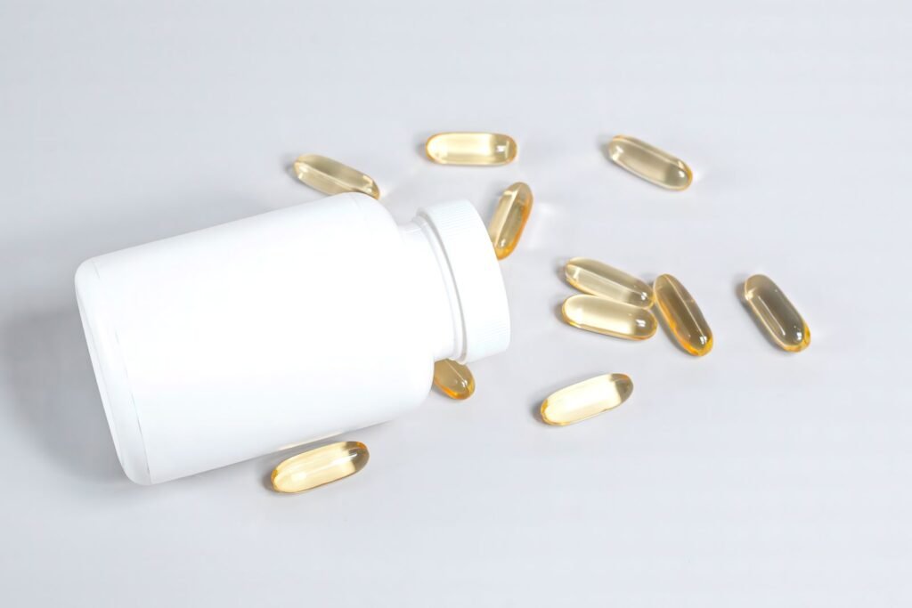 White supplement bottle with softgel capsules spilled beside it