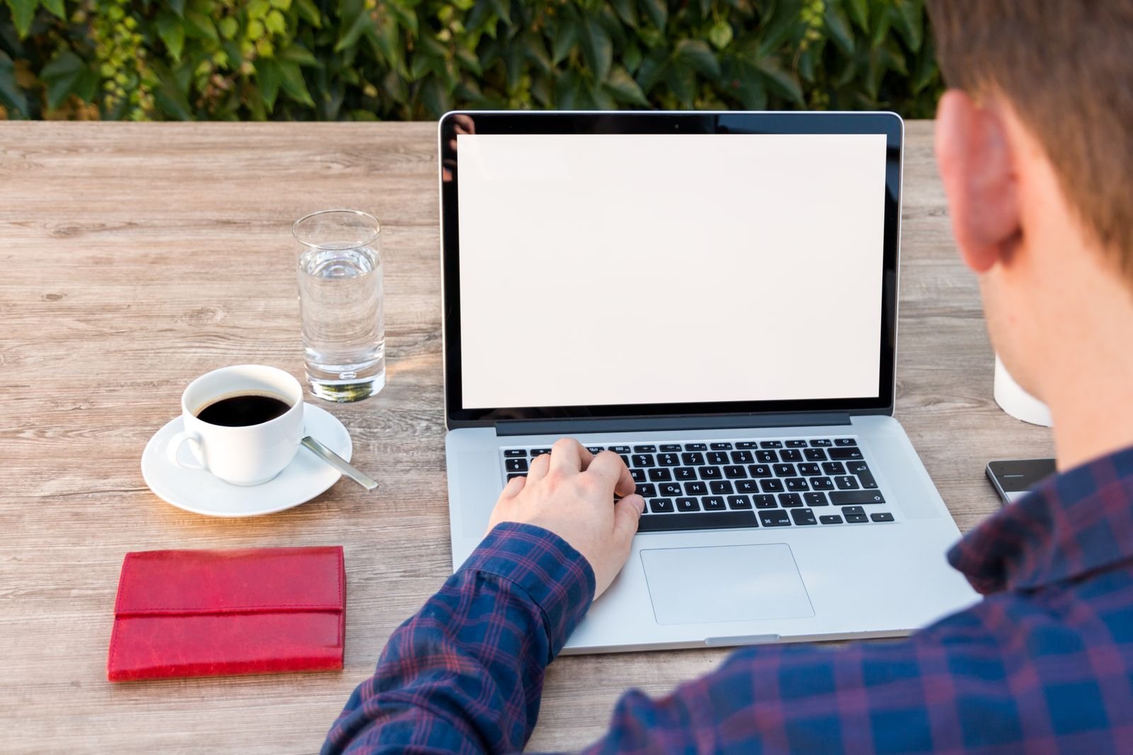 Laptop, notepad and coffee on an outdoor work table
