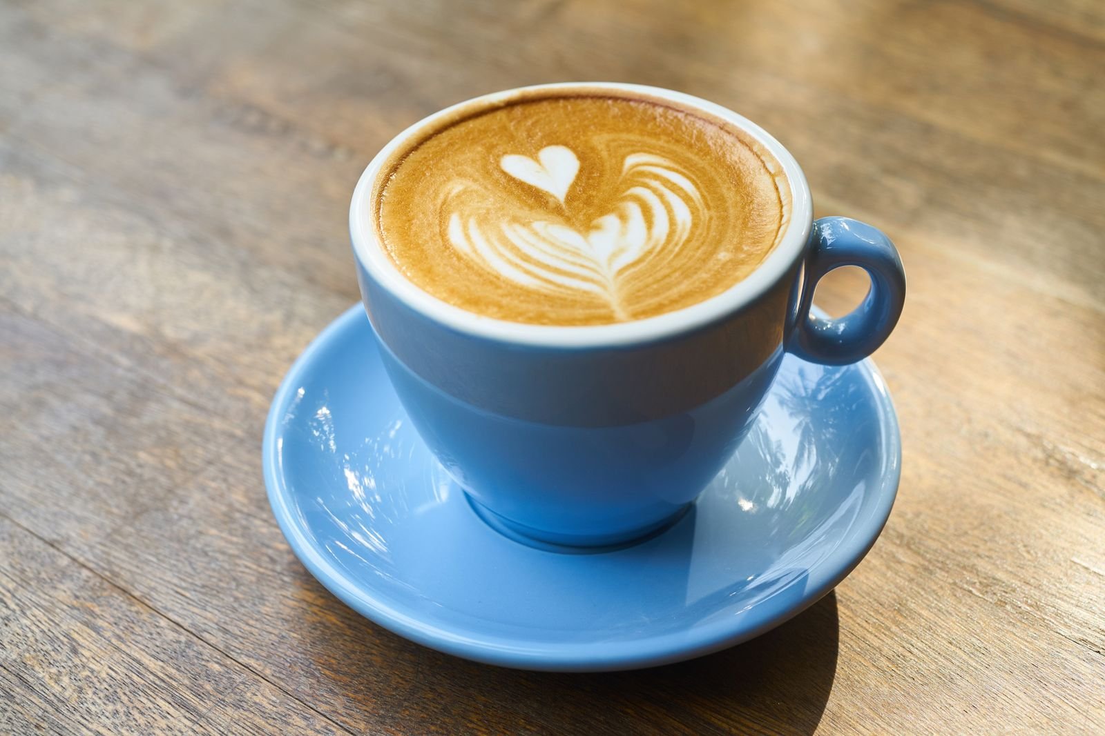 Latte with heart-shaped art in a blue cup