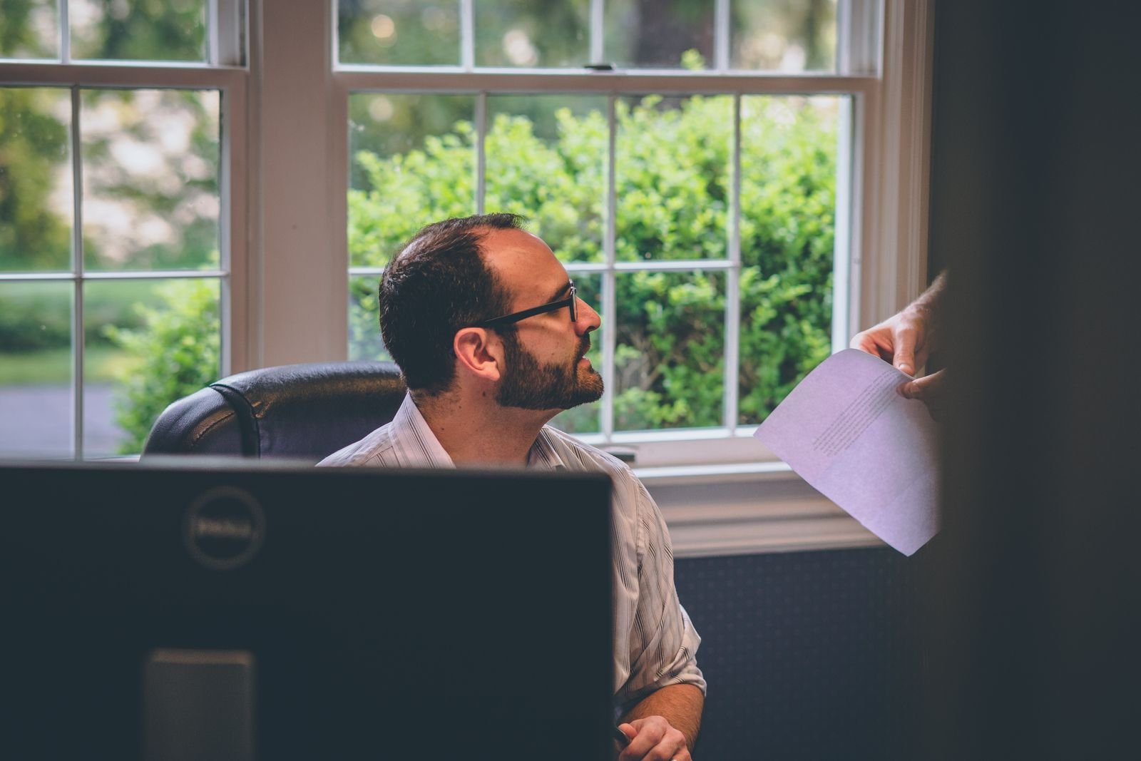 Man at his desk looking up from his work