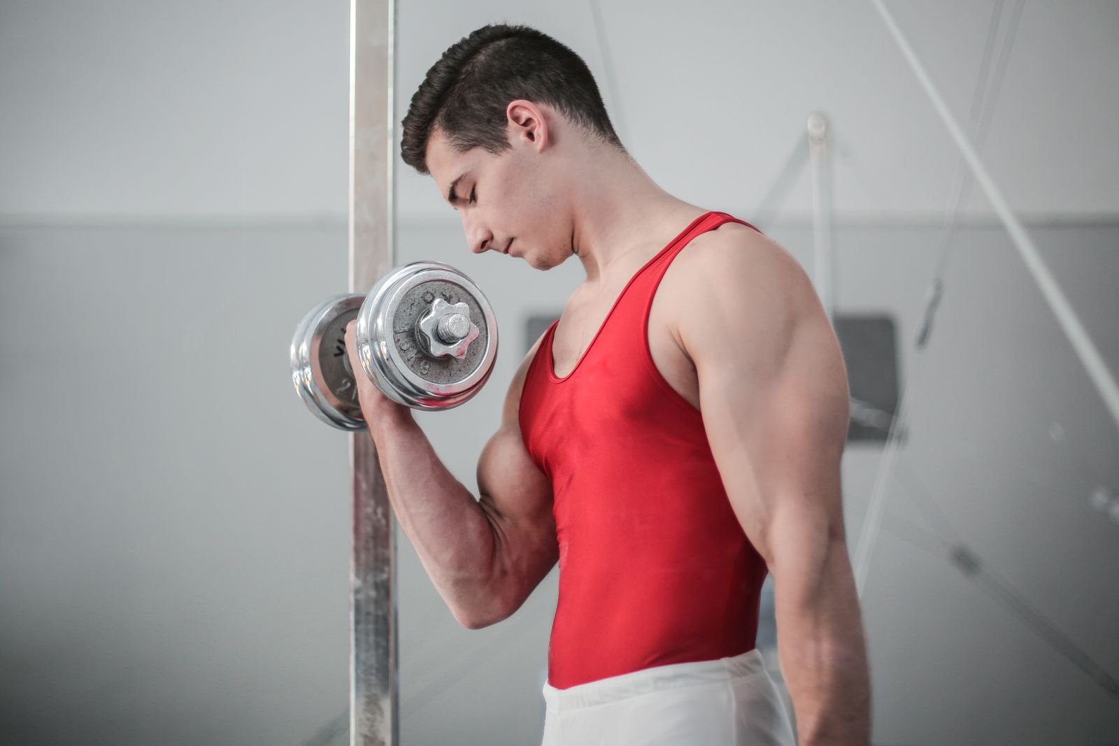 Man doing a dumbbell curl in a gym