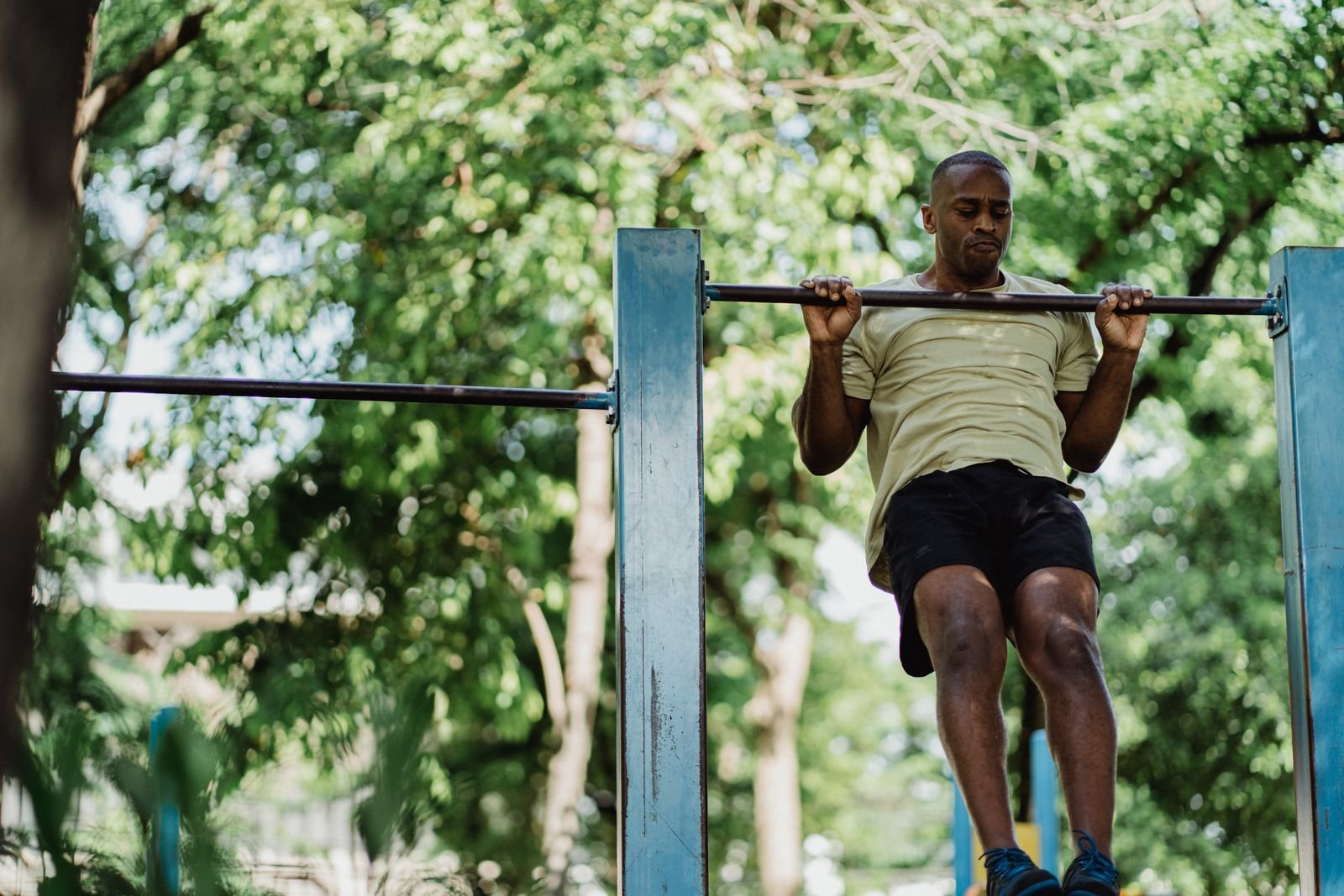 Man doing a pull-up on an outdoor bar