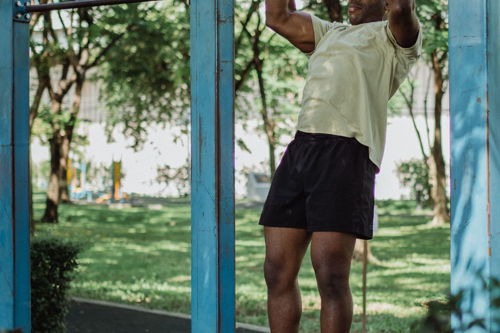 Man doing pull ups on an outdoor bar
