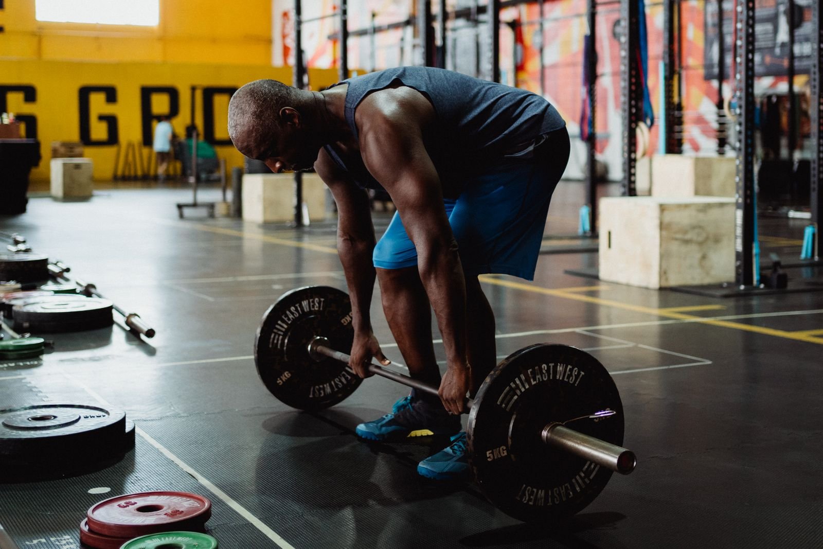 Man lifting a barbell from the floor in a gym