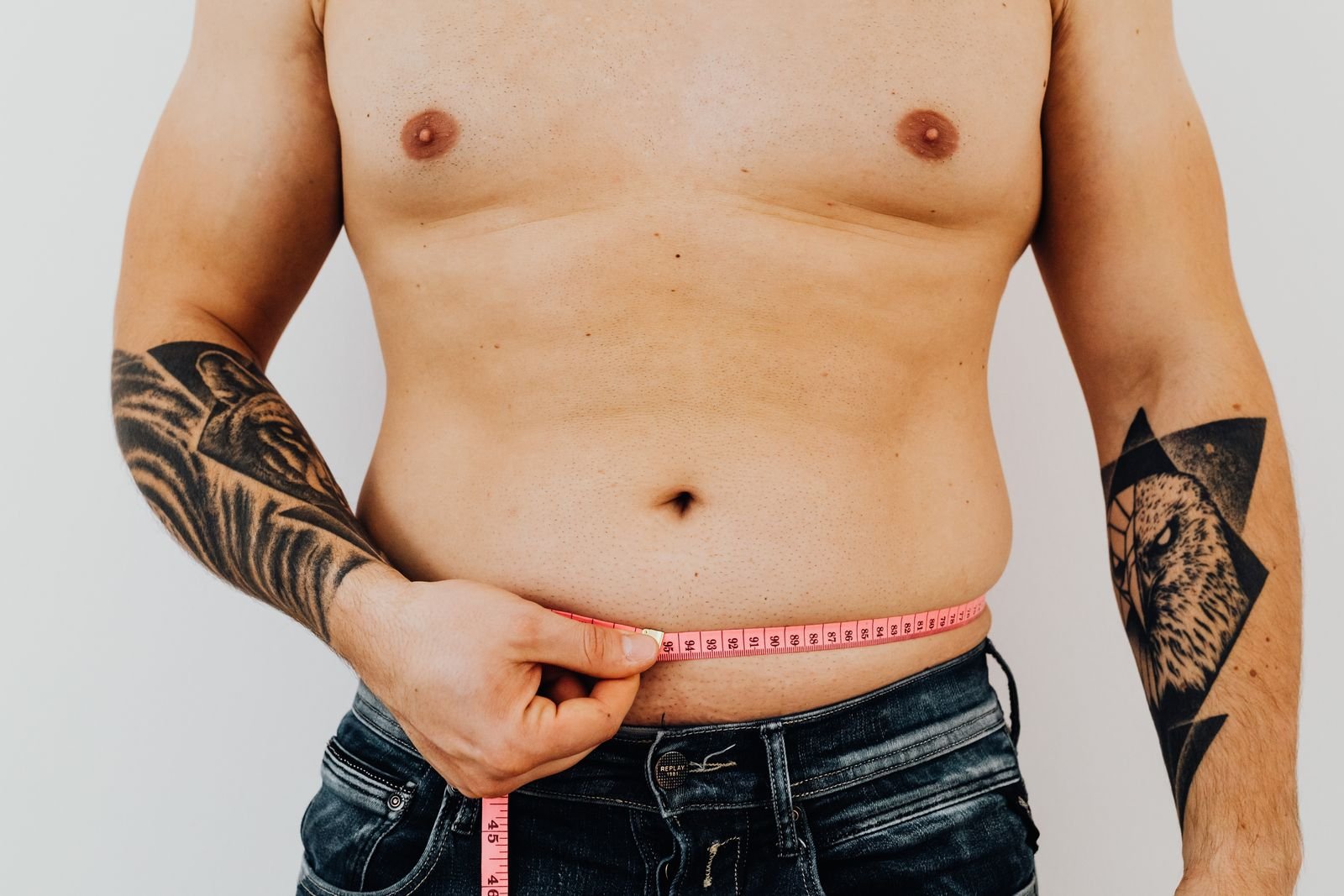 Man measuring his waist with a tape measure