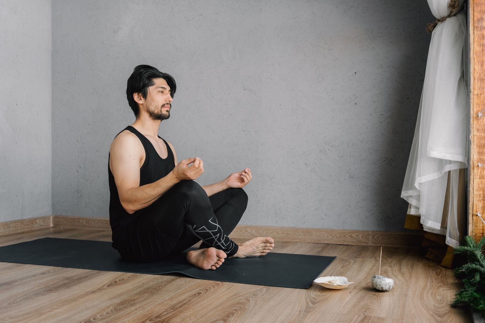 Man meditating on a yoga mat at home