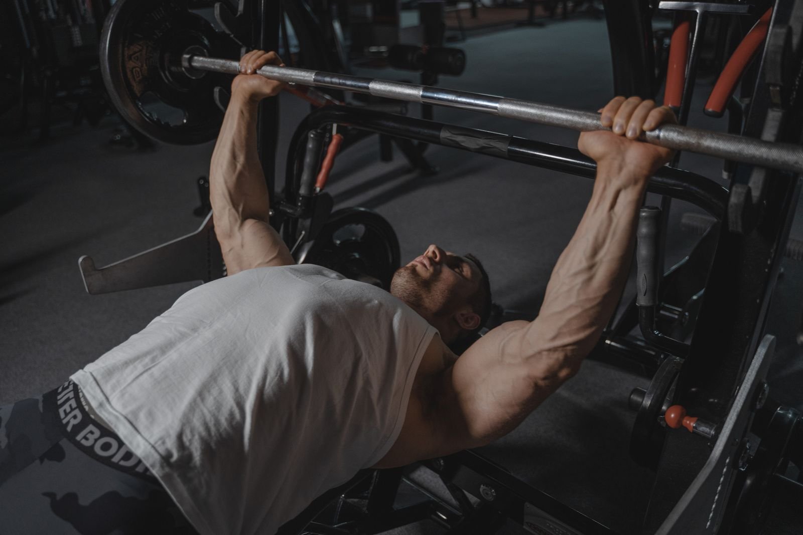 Man pressing a loaded barbell on a flat bench