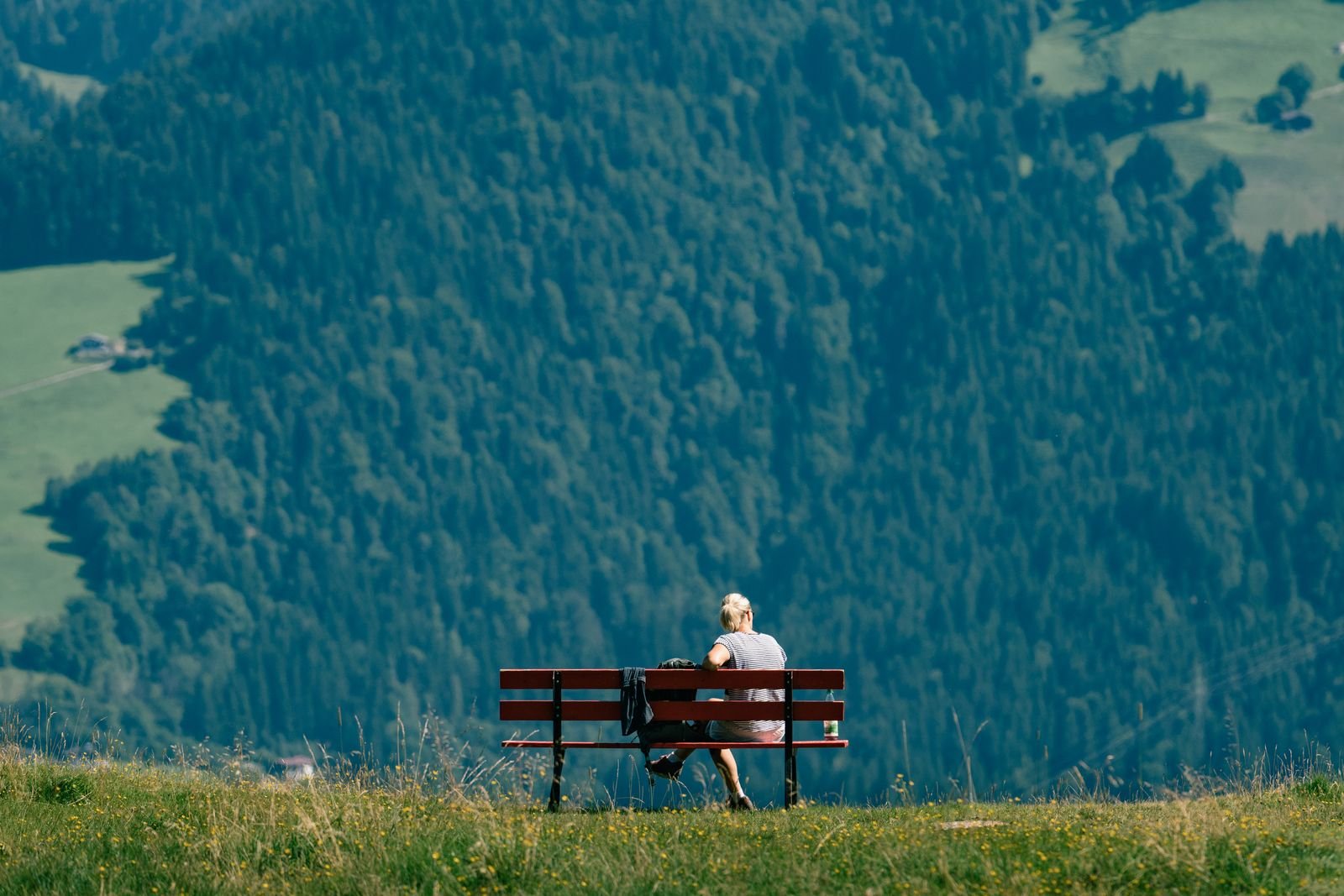 Man sitting alone on a bench looking out